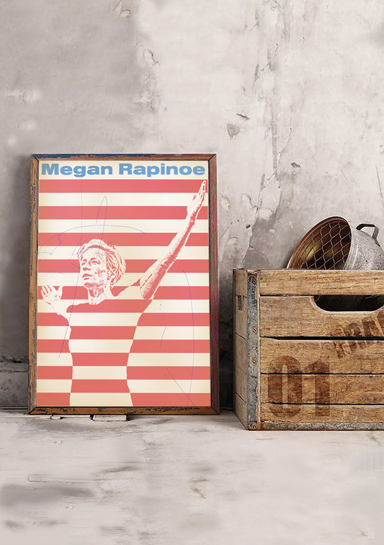 Poster rouge et blanc avec Megan Rapinoe, bras levé, tenant un ballon de football.