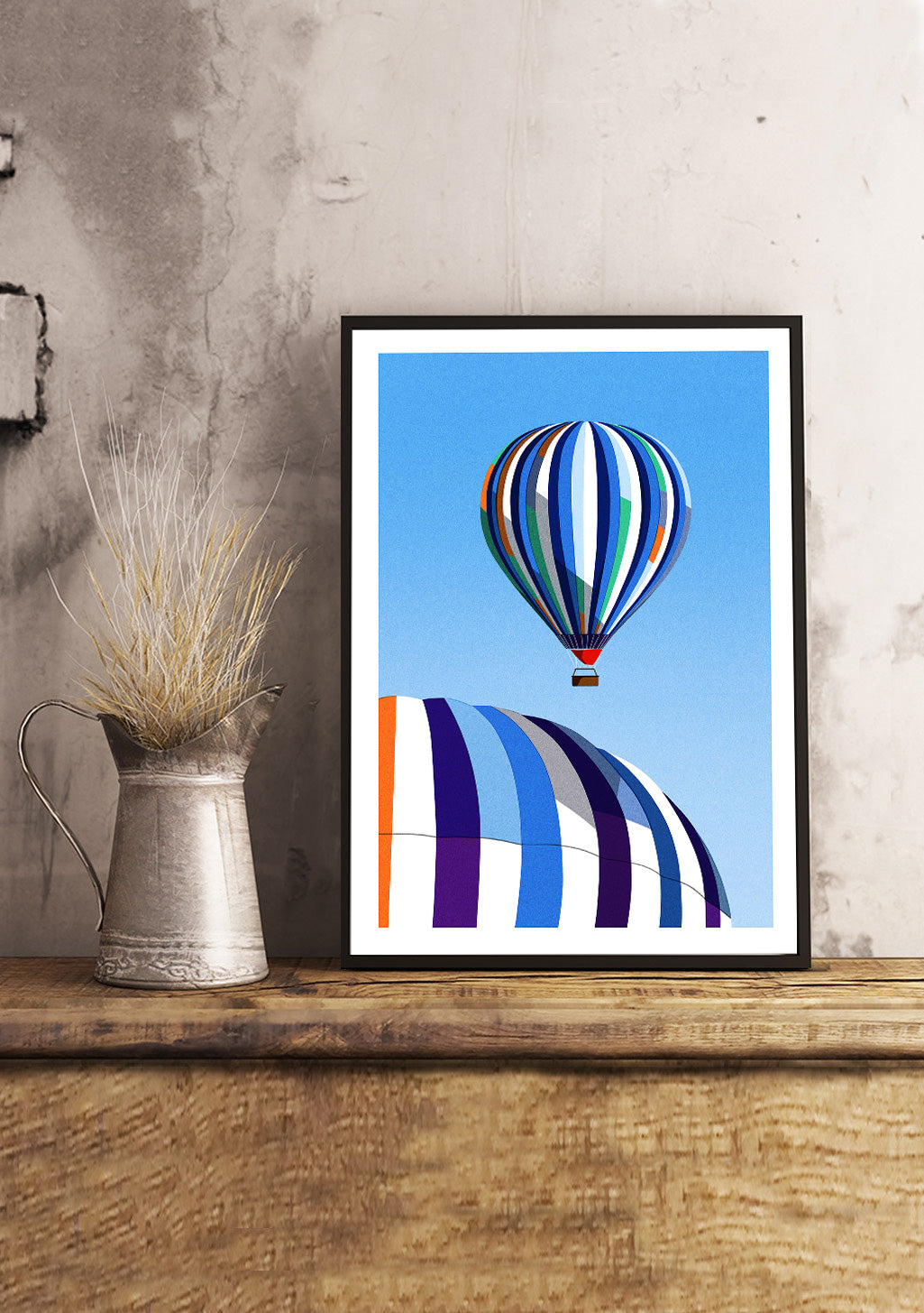 Ballon dirigeable multicolore, fond bleu, collines stylisées